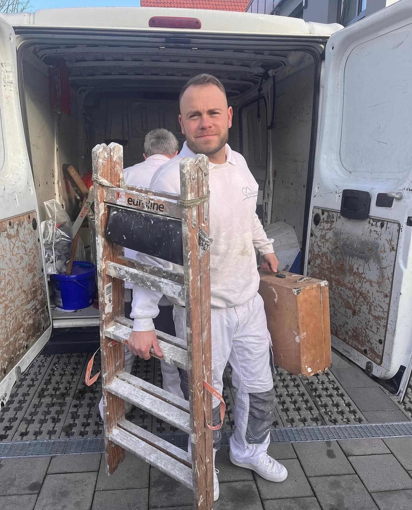 Martial Drescher, Inhaber des Haus & Gartenteams, in Arbeitskleidung am Firmenfahrzeug